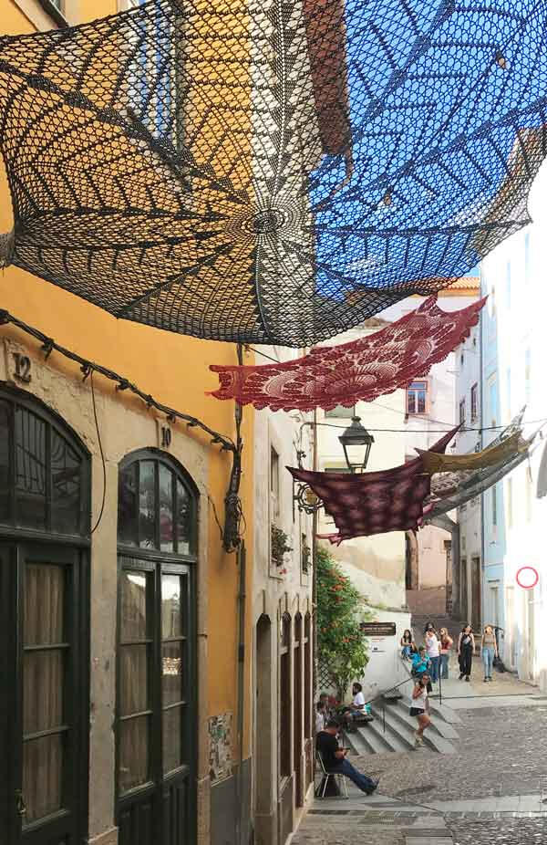 Public art, Coimbra - community-made crochet installations draw on heritage craft to create shade and social presence in the city’s streets.